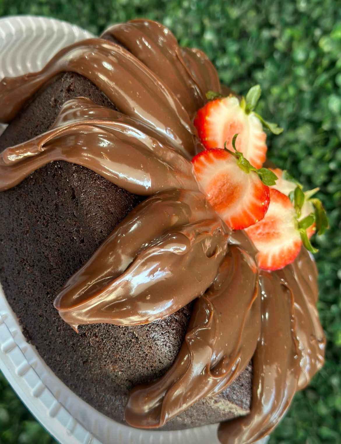 Bolo de chocolate com cobertura cremosa e morangos