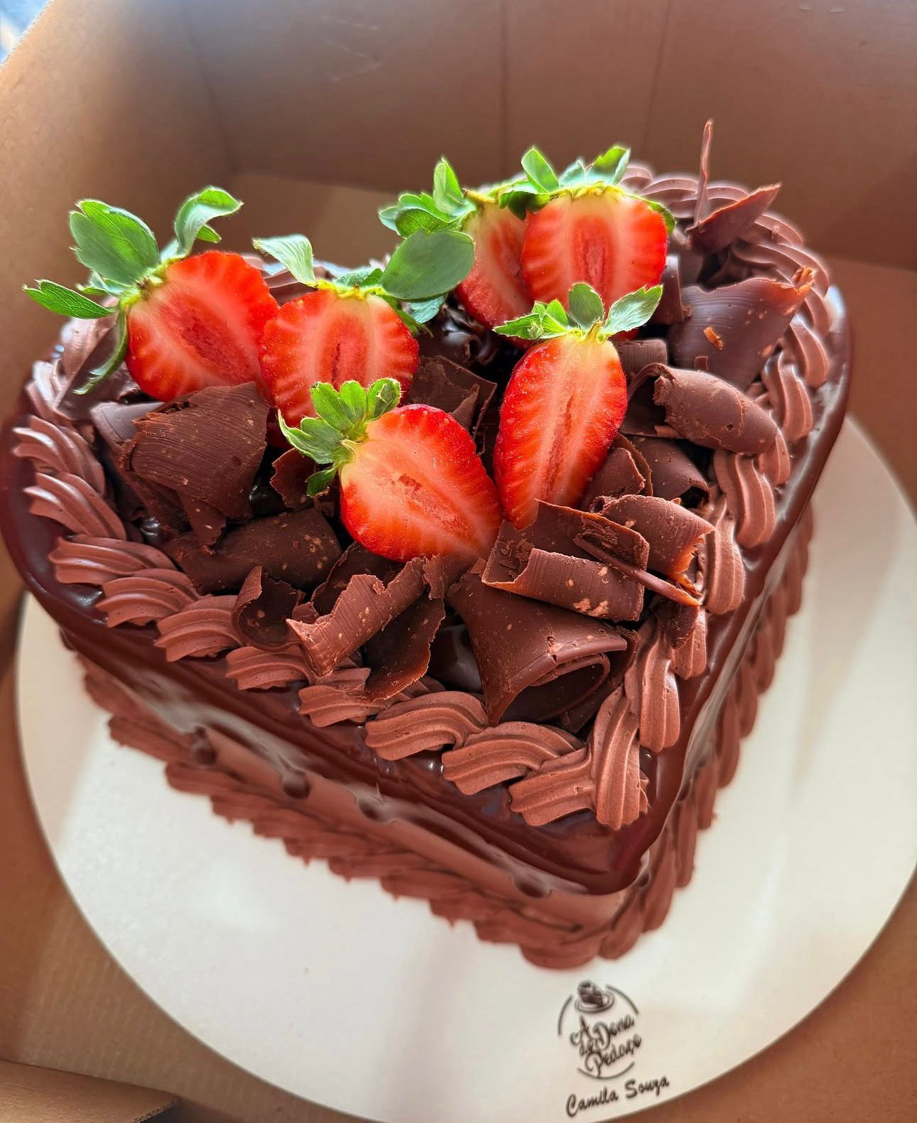 Bolo de chocolate em formato de coração com morangos